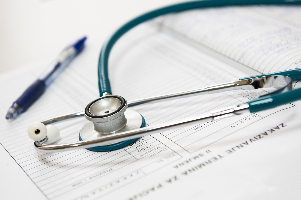 stethoscope resting on top of a medical form or document, with a pen placed nearby