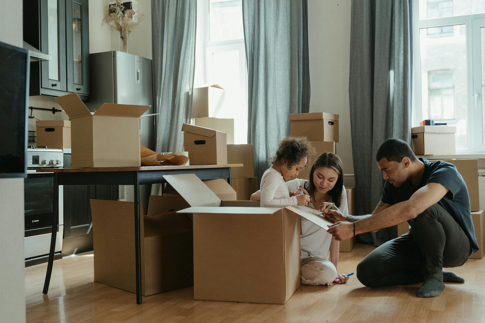 A family unpacks moving boxes in their new home kitchen, creating a cozy atmosphere, renters